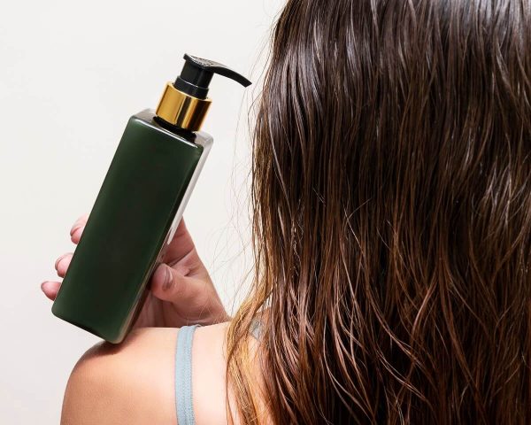 woman-holds-bottle-shampoo-hair-balm-her-shoulder-her-wet-hair